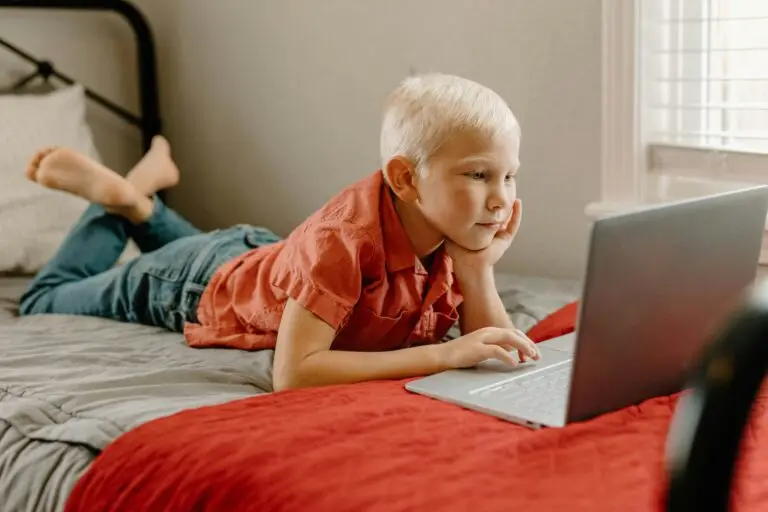 ADHD boy lying on a bed using a laptop