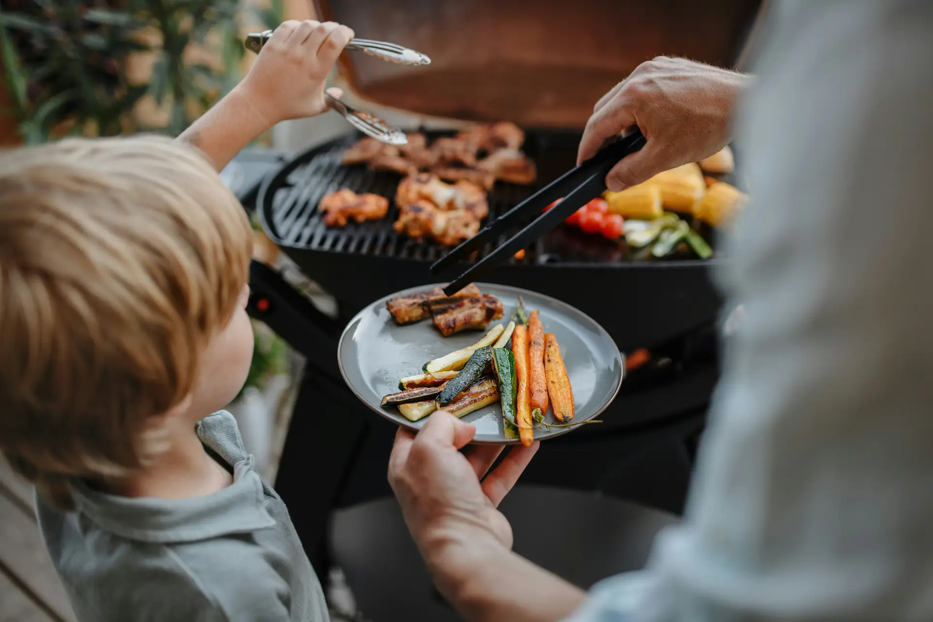Fussy child trying food cooked on a BBQ