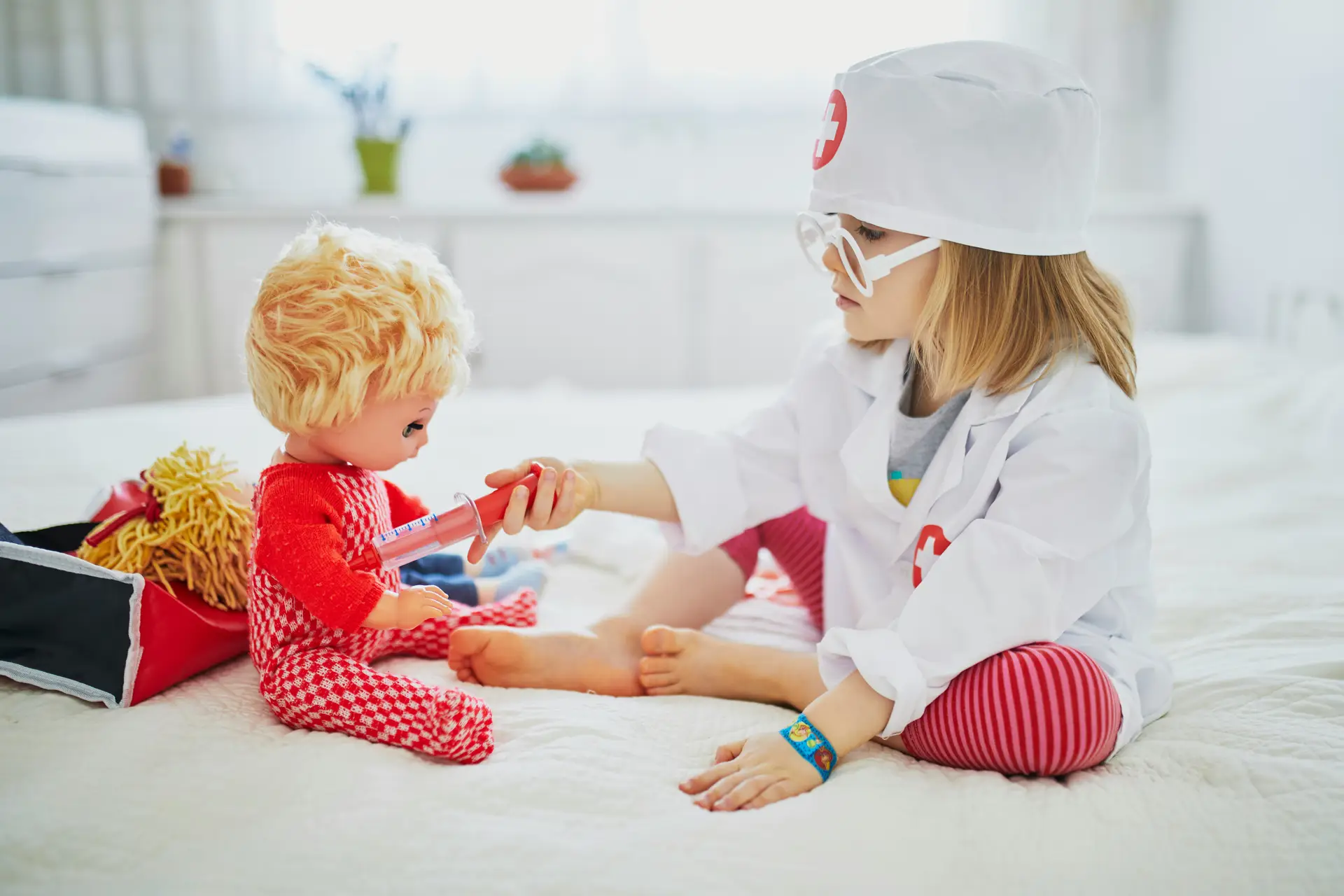 Child playing doctors with dolls