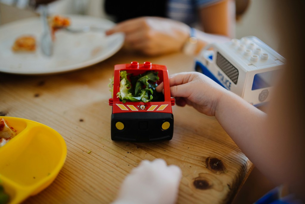 ARFID, fussy eating, picky child with ASD or ADHD playing with lettuce and a car