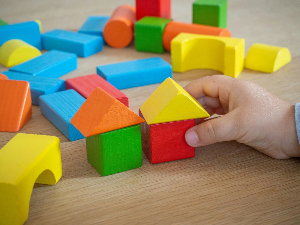 Childcare worker helps ASD child with blocks